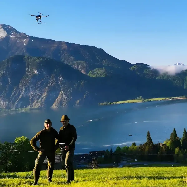 Jäger steuern die Kitzrettungsdrohne Bambi650 von Smartmulticopters im Hintergrund erstreckt sich der Mondsee