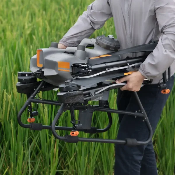 Zusammengefaltete Landwirtschaftsdrohne DJI Agras T10 wird zum Startplatz im Feld getragen