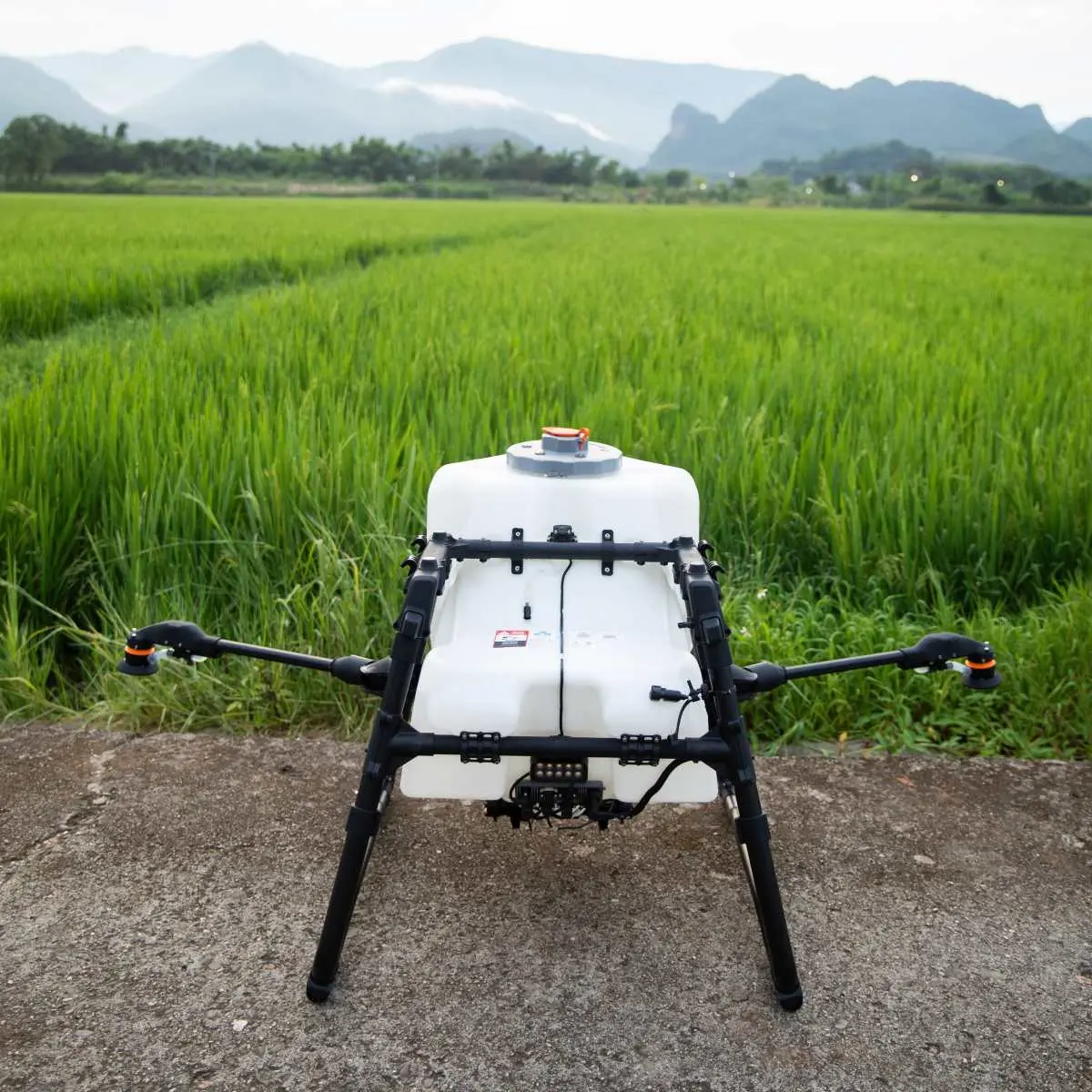 DJI LS100 Dualer Sprühsystem Kit von hinten steht vor Feld